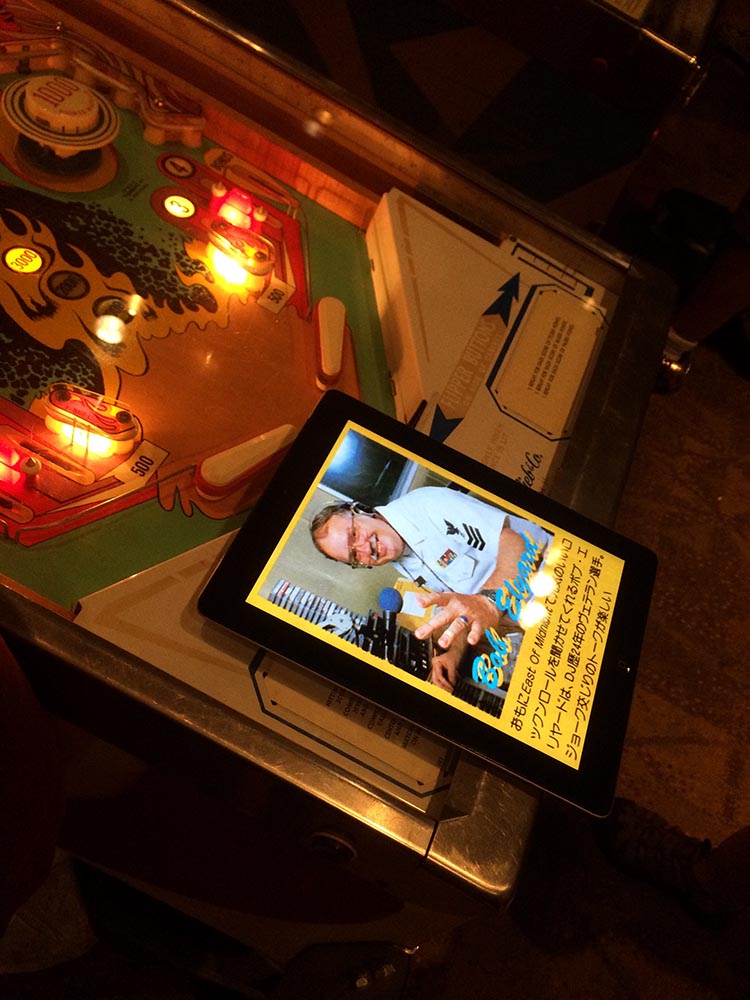An image of Robert Elyard on an iPad sitting on a pinball table.
