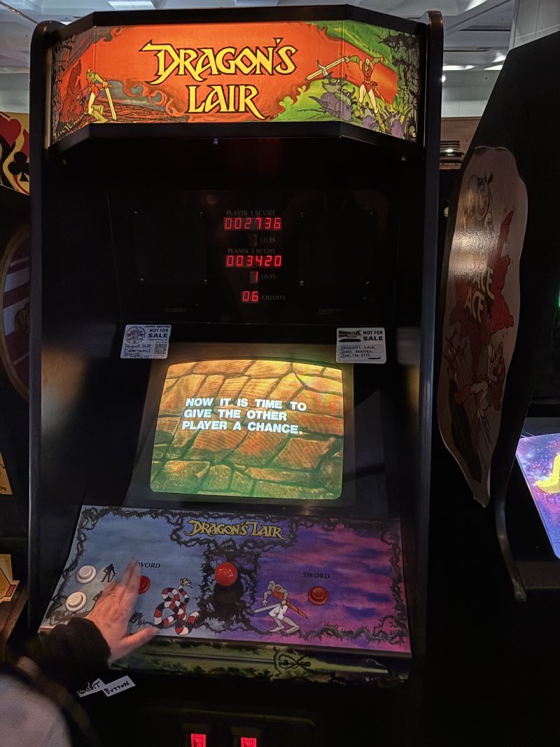 Dragon's Lair video arcade cabinet. The screen reads, "Now it is time to give the other player a chance."